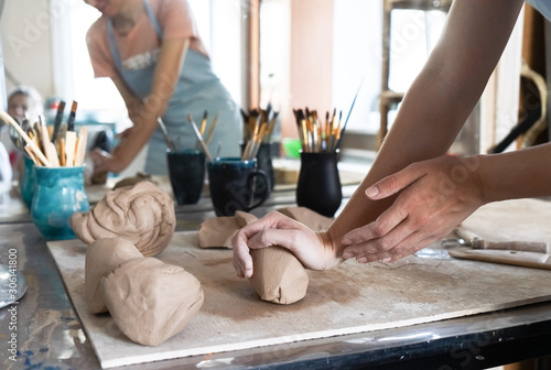 Stampa su tela A Potter girl kneads a piece of clay with her hands in her Studio workshop