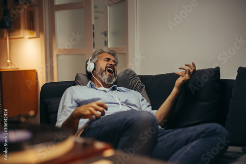 middle aged man relaxing at his home listening records photo