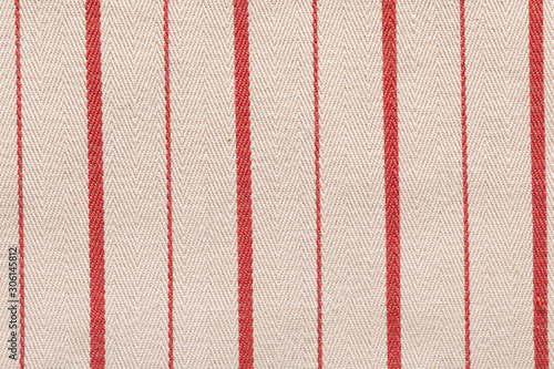 Red fabric pattern striped texture. Colored striped coarse linen fabric closeup as background.
