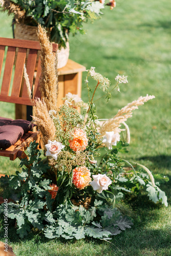 Outdoor wedding ceremony. Composition of chrysanthemums, pampas grass and oak branches