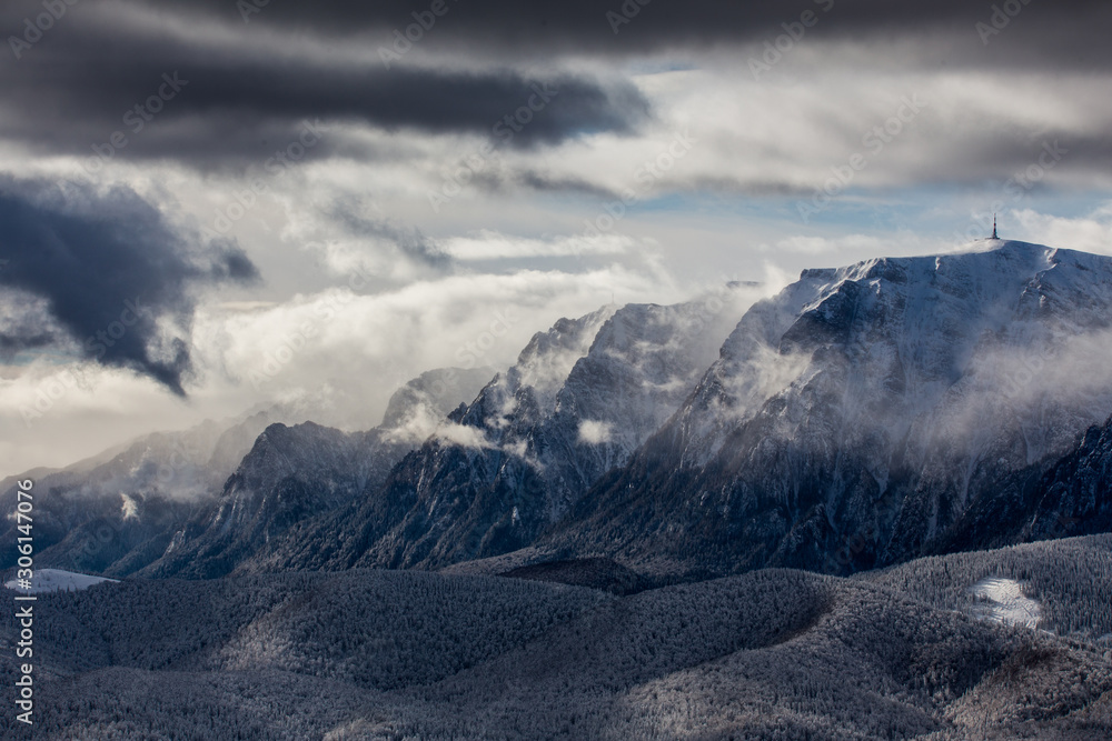 Obraz premium Beautiful mountain panorama in winter with fog and clouds. Bucegi mountains seen from Postavaru, Romania.