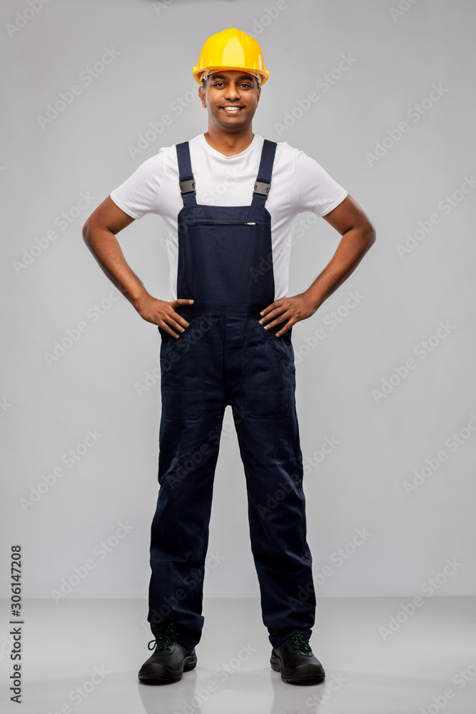 profession, construction and building - happy smiling indian worker or builder in helmet over grey background profession, construction and building - happy smiling indian worker or builder in helmet over grey background