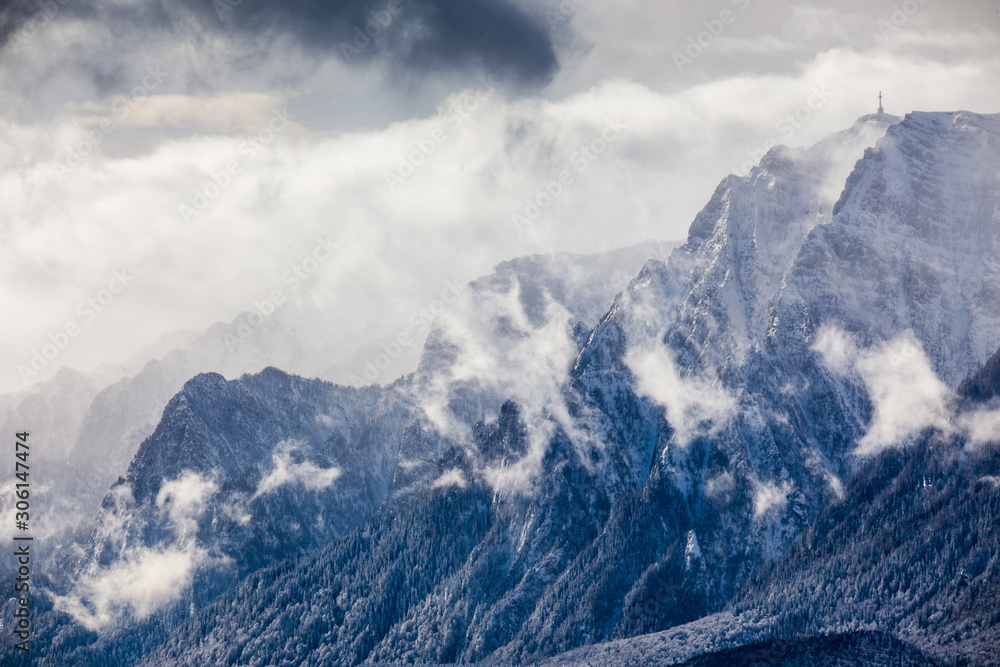 Obraz premium Beautiful mountain panorama in winter with fog and clouds. Bucegi mountains seen from Postavaru, Romania.