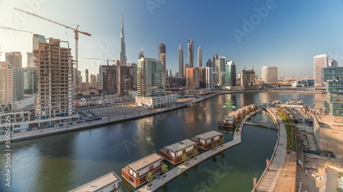 Skyscrapers near canal in Dubai with blue sky aerial timelapse