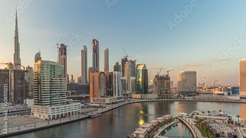 Skyscrapers near canal in Dubai with blue sky aerial timelapse