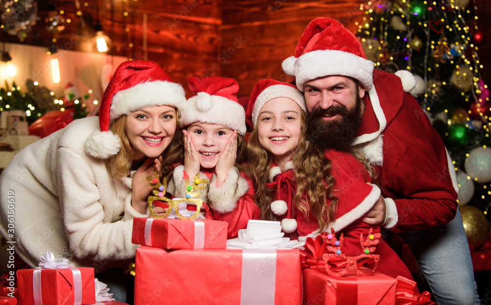New 2020 Year is coming. Happy family celebrate new year. merry christmas. Father and mother love kids. small children and parents in santa hat. lot of xmas present boxes. Portrait loving family