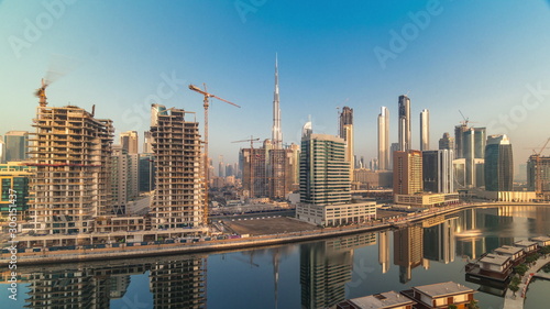 Skyscrapers near canal in Dubai with blue sky aerial timelapse