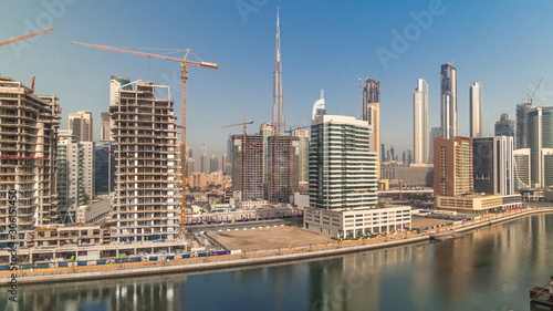 Skyscrapers near canal in Dubai with blue sky aerial timelapse