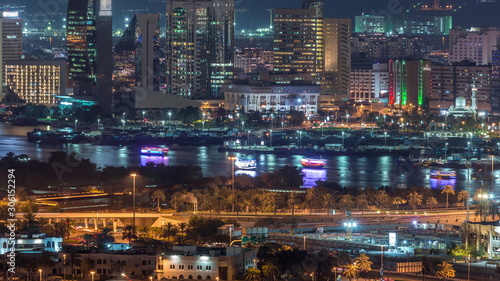The rhythm of the city at night. View of skyscrapers and canal in Dubai near canal aerial timelapse