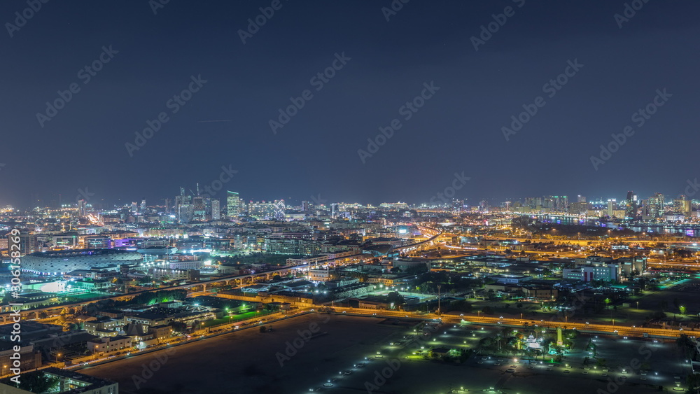 Fototapeta premium The rhythm of the city at night with illuminated road in Dubai near canal aerial timelapse