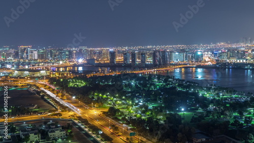 Nighttime rhythm of the city of Dubai near canal aerial timelapse