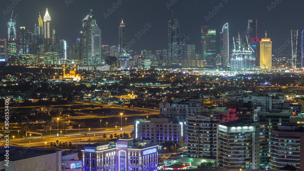 Naklejka premium Modern view of illuminated buildings appartments and skyscrapers in Dubai Timelapse Aerial