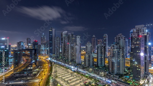 Modern residential and office complex with many towers aerial night timelapse at Business Bay  Dubai  UAE.