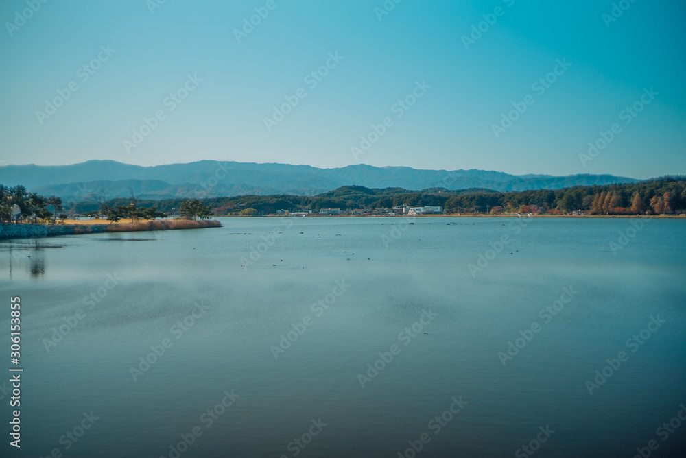 Calm surface of lake and long shot of layered mountains at Gangneung, South Korea Calm surface of lake and long shot of layered mountains at Gangneung, South Korea