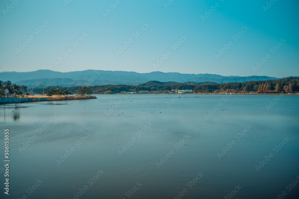 Calm surface of lake and long shot of layered mountains at Gangneung, South Korea