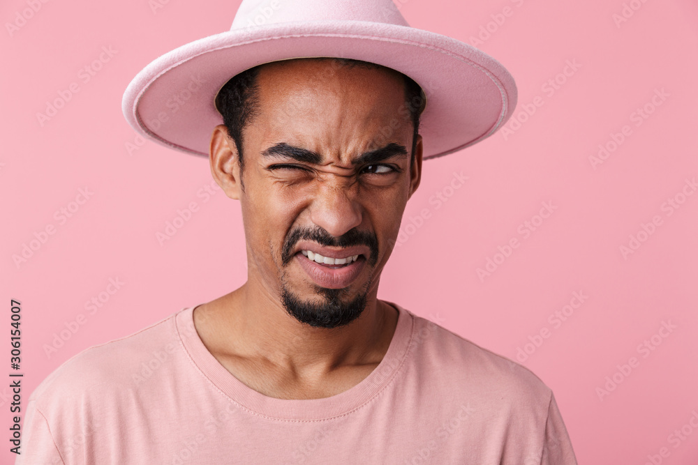 Photo of displeased african american man winking and looking aside Photo of displeased african american man winking and looking aside