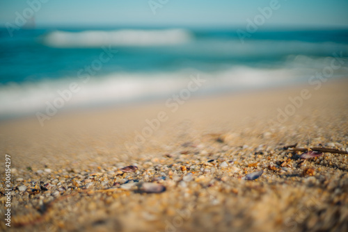 Focus on the sandy beach and focused out gentle waves on a clear fine day with no cloud in the sky
