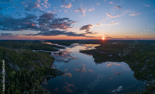 An aerial view at sunset of Winnange Lake located in Northwest Ontario, Canada on a calm and colorful summer evening.
