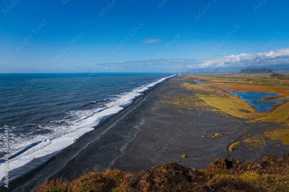 Reynisfjara Black Sand Beach, found on the south coast of Iceland near the village of village of Vik i Myrdal, seen from a cliff during a sunny day. September 2019
