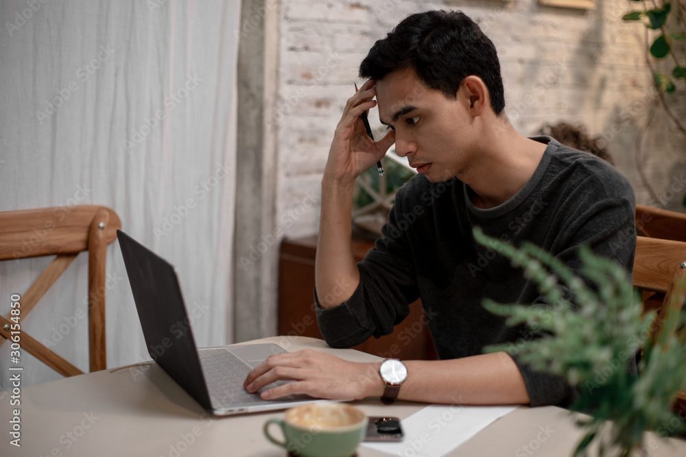 a man is working in his house and drinking coffee and using his mobile talking to his co worker a man is working in his house and drinking coffee and using his mobile talking to his co worker