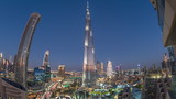 Panoramic skyline view of Dubai downtown after sunset with mall, fountains and skyscrapers aerial day to night timelapse