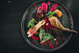 Michelin restaurant serving organic duck meat with kale and Beet puree on dark plate, chef cooking food