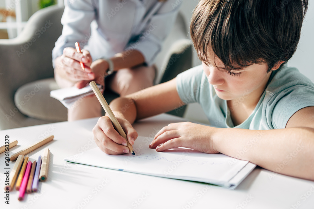 selective focus of kid with dyslexia drawing on paper with pencil selective focus of kid with dyslexia drawing on paper with pencil
