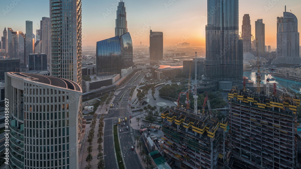 Obraz premium Panoramic skyline view of Dubai downtown before sunrise with mall, fountains and skyscrapers aerial night to day timelapse