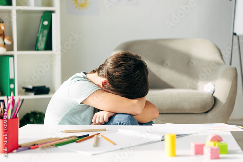 side view of sad kid with dyslexia crying in clinic photo