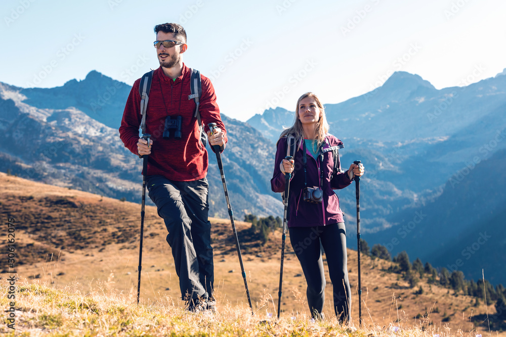 Two travel hikers with backpack walking while looking the landscape in the mountain.