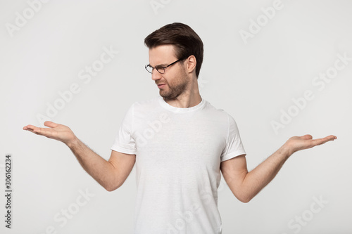 Bilde på lerret Doubtful Caucasian man make choice hesitating about two options
