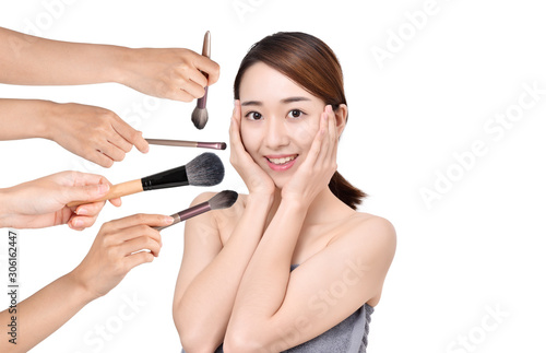 Portrait of beautiful woman with make-up brushes on white background