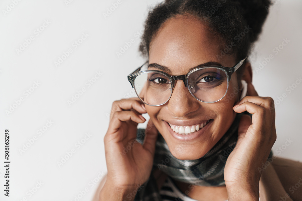 Portrait of african american joyful woman laughing and using earpods Portrait of african american joyful woman laughing and using earpods