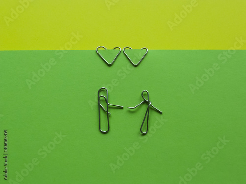 meeting of lovers .installation of paper clips on a green background.