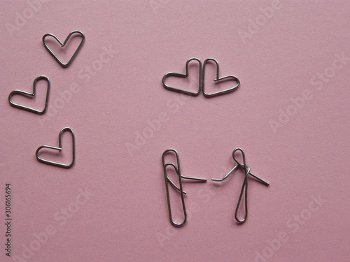 meeting of lovers .installation of paper clips on a pink background.