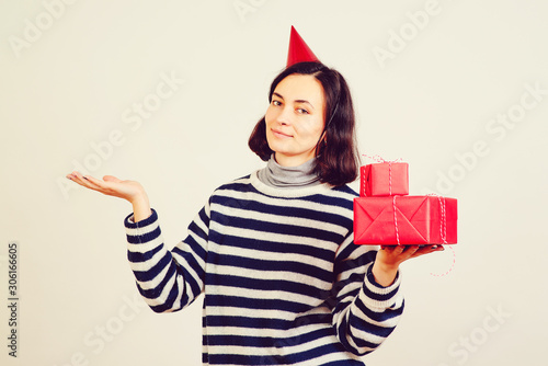 Charming woman in winter clothes with gifts. Girl holds birthday gift boxes. Christmas party, gifts and mood