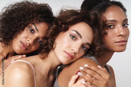 Portrait of three attractive multiethnic women hugging together