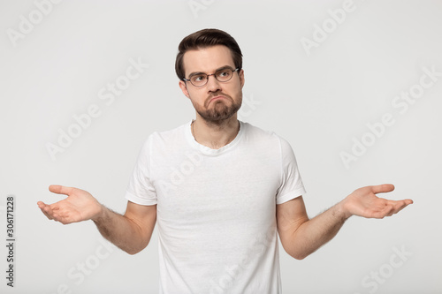 Unsure Caucasian man shrug shoulders feel doubtful