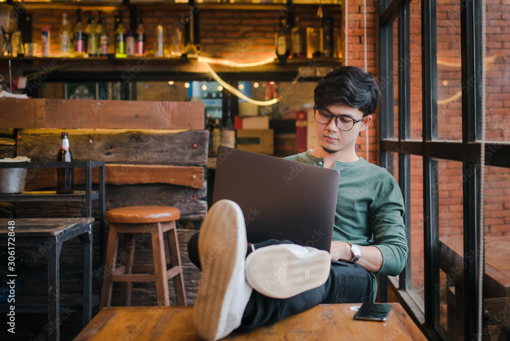 young asian man freelancer working at home on a computer