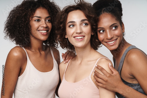 Portrait of three happy multiethnic women smiling and looking aside