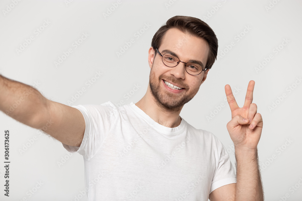 Smiling millennial man in glasses make selfie in studio Smiling millennial man in glasses make selfie in studio
