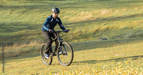 Cyclist in pants and fleece jacket on a modern carbon hardtail bike with an air suspension fork. The guy on the top of the hill rides a bike. © Mountains Hunter