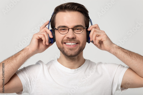 Happy millennial man listen to music in new Bluetooth headphones