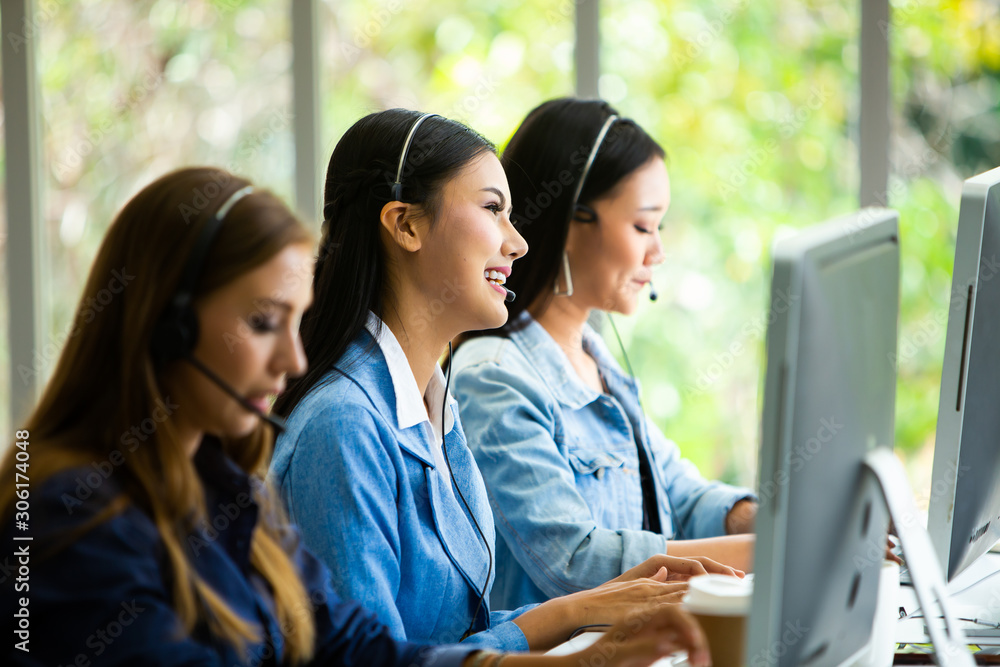 © NVB Stocker - Attractive business woman Asian in suits and headsets are smiling while working with computer at office. Customer service assistant working in office