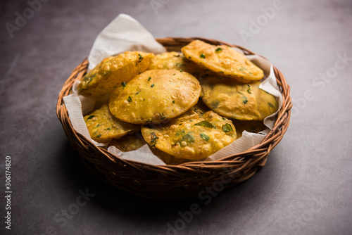 Methi Poori or Puri made using Fresh fenugreek leaves missed with wheat flour, by making small pancake size shapes deep fried in oil, served with tea photo