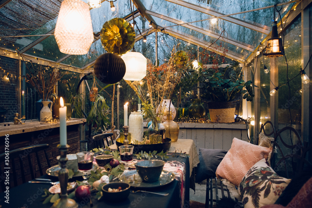 Decorated greenhouse in trendy christmas setting with dinner table