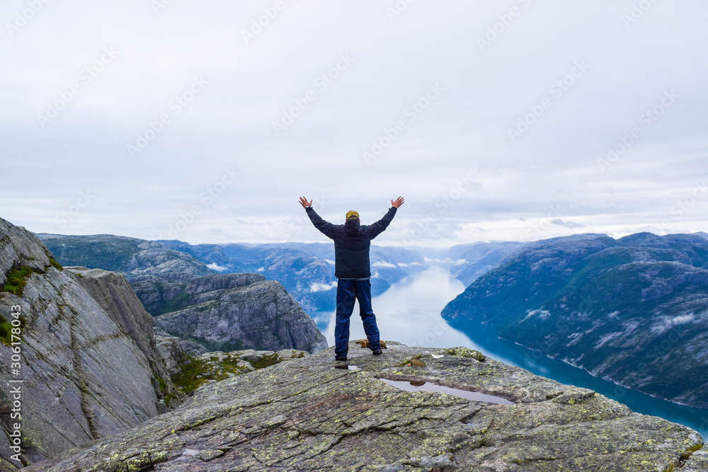 Joyful man on the background Lysefjord landscape, Pulpit Rock (Prekestolen). Norway. Joyful man on the background Lysefjord landscape, Pulpit Rock (Prekestolen). Norway.