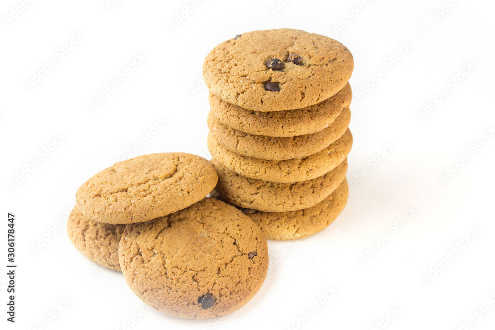 A stack of oatmeal cookies on an isolated background is standing next to a pile of biscuit. A stack of oatmeal cookies on an isolated background is standing next to a pile of biscuit.