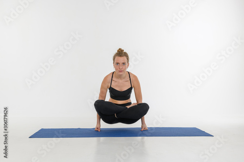 Sporty attractive young woman doing yoga practice on white background.