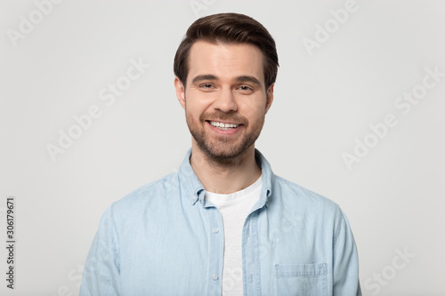 Portrait of smiling Caucasian man posing on grey background © fizkes